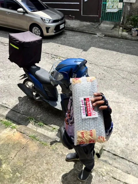 Courier holding a bubble-wrapped graphics card parcel