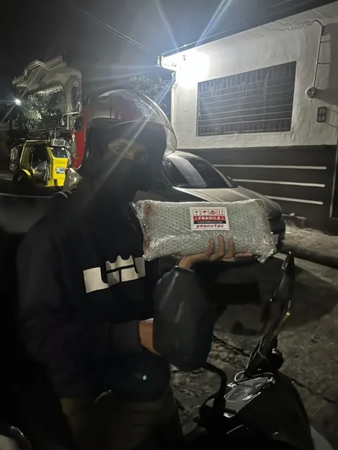 Evening parcel handover to a delivery rider