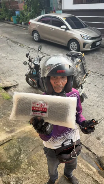 Delivery rider holding a wrapped Peanut PC order